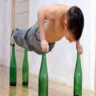  Menino de sete anos se equilibra em quatro garrafas de vidro e faz flexões