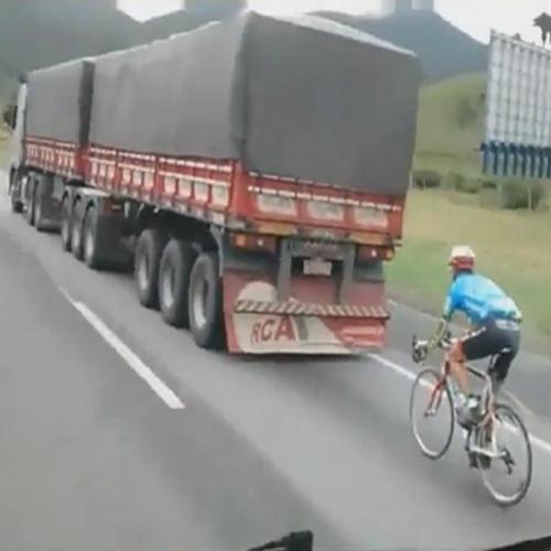 	 Ciclista corre em alta velocidade em auto estrada na bicicleta