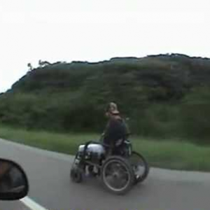 Homem dirige cadeira de rodas a 80 km por hora em estrada