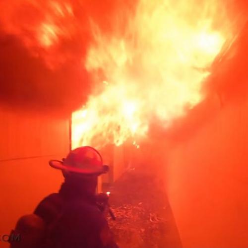 Bombeiros em treinamento de combate a incêndio em uma casa abandonada