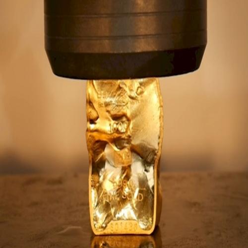Prensa hidráulica versus barra de ouro de 1.000 gramas