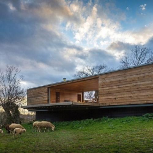 Casa de madeira construída no campo aberta para a natureza