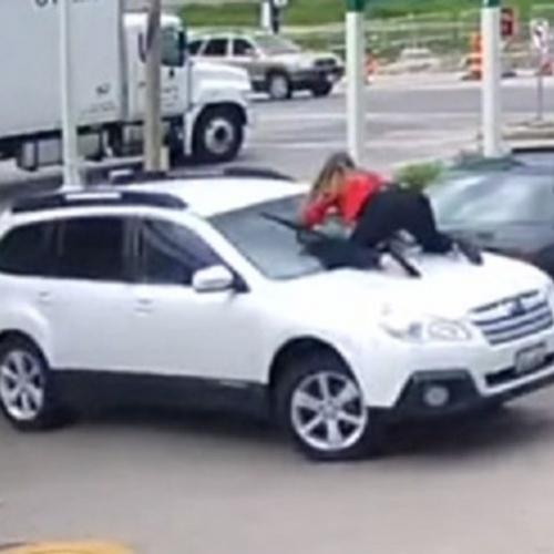 Mulher sobe no capô do seu carro para impedir roubo